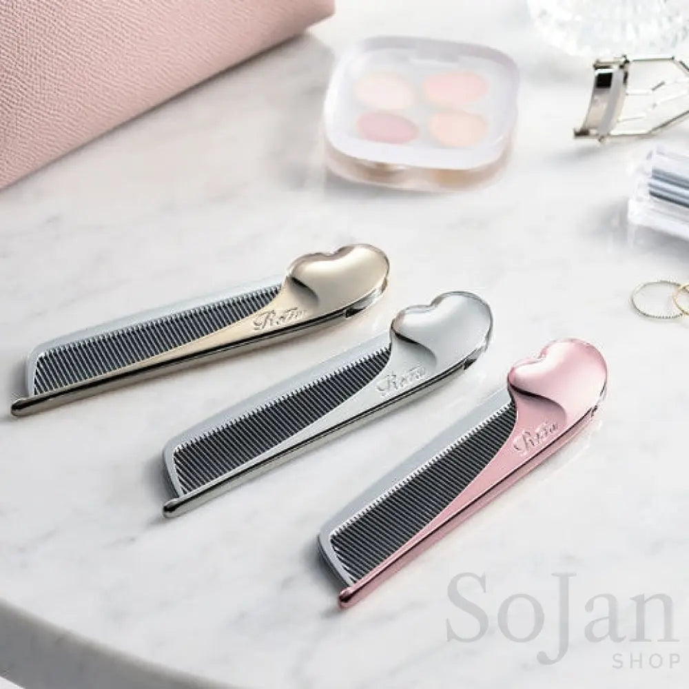 Three ReFa HEART COMB Aira combs on marble beside a pink pouch