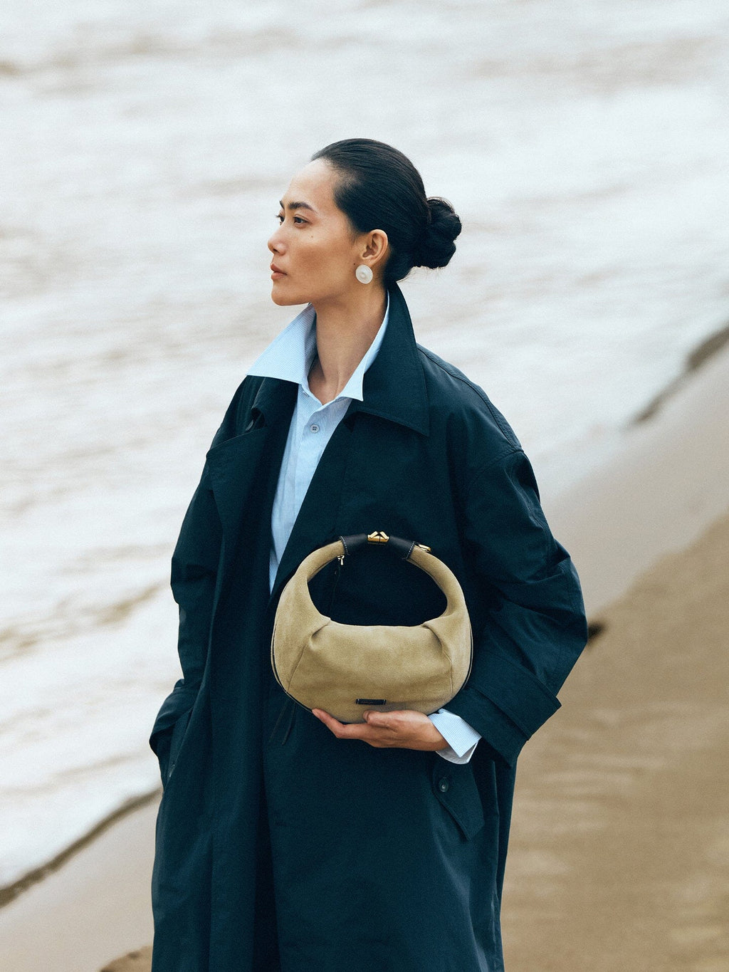 Songmont Medium Luna Hobo Bag Dune Suede - carried by hand on a beach