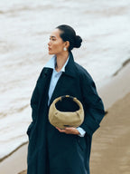 Songmont Medium Luna Hobo Bag Dune Suede - carried by hand on a beach