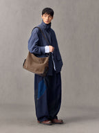 Songmont Large Yore Hobo Bag Stone - worn across the body with a denim jacket