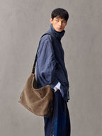 Songmont Extra Large Yore Hobo Bag Stone - worn across the body with a blue linen shirt