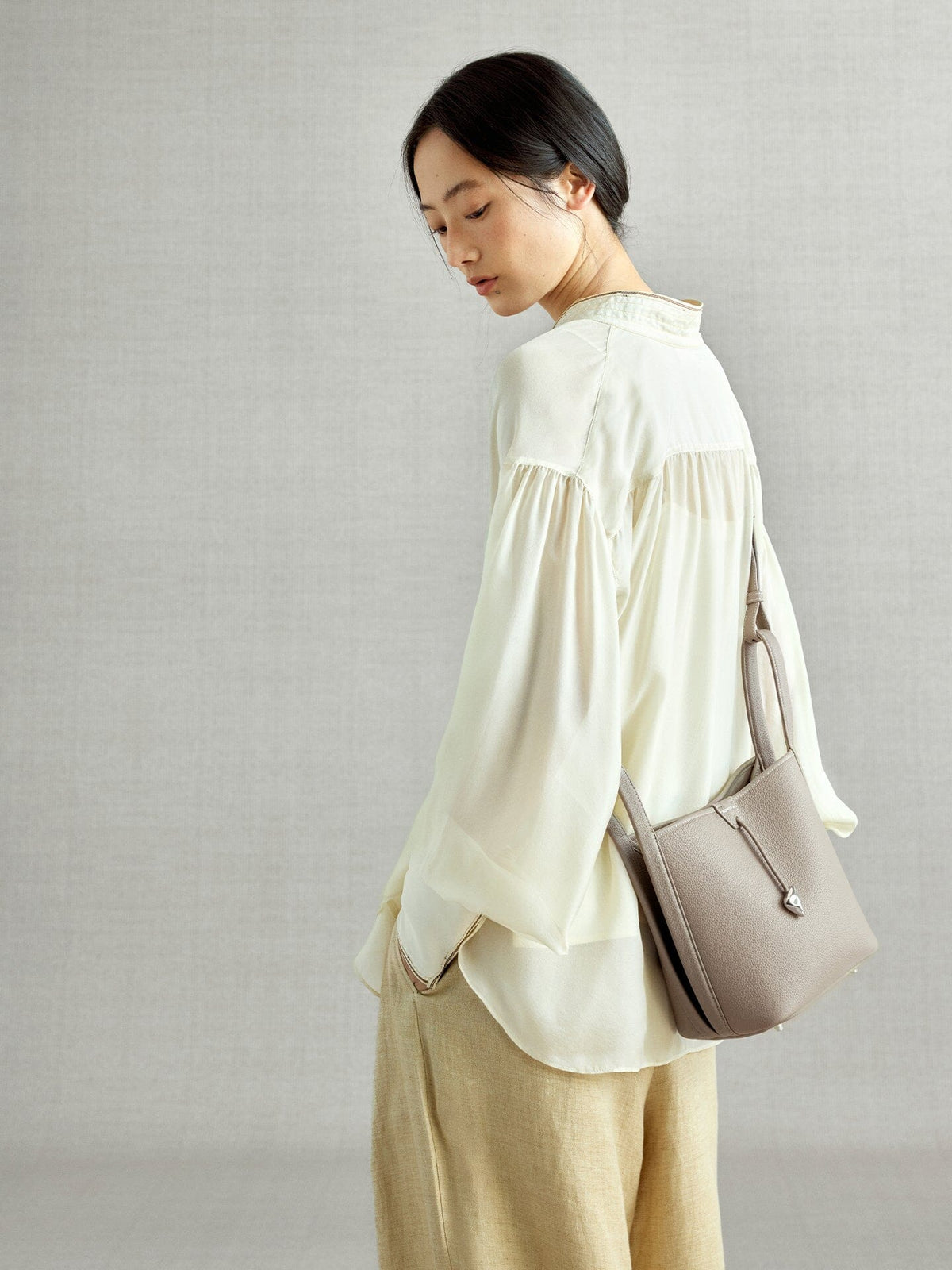 Songmont Song Bucket Bag Cobble - worn cross-body, side view