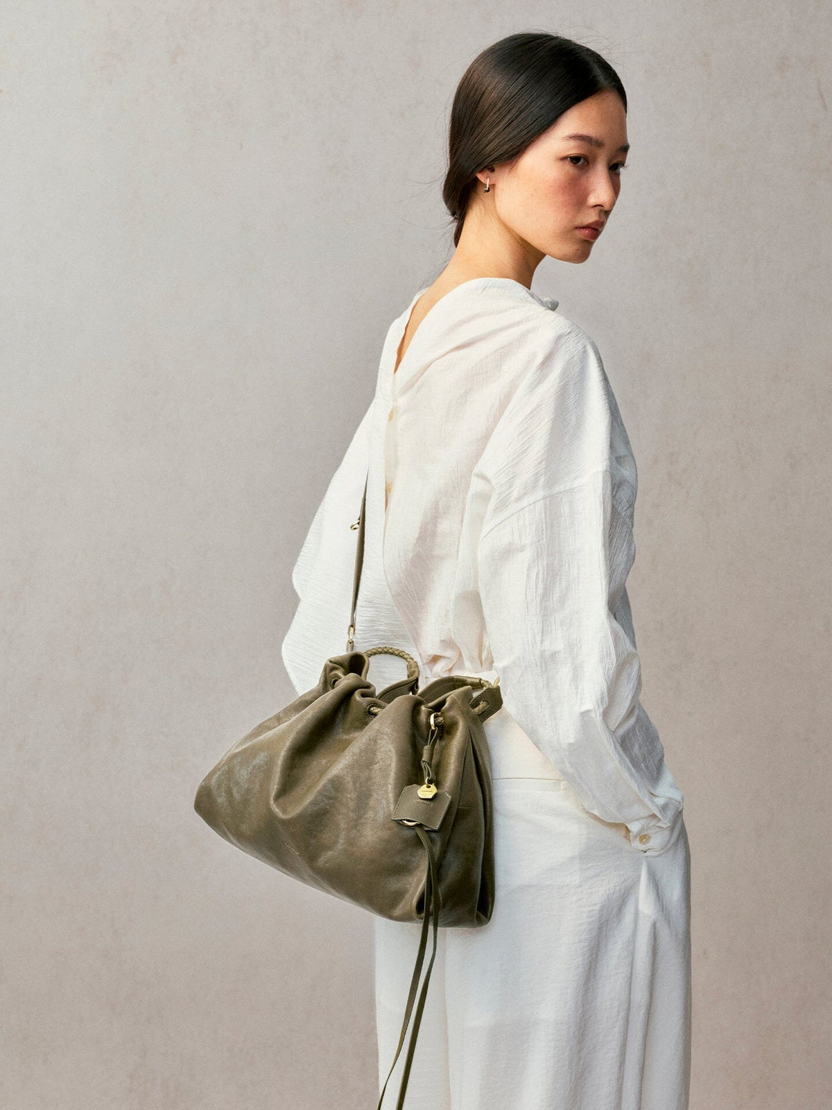 Songmont Small Gather Bag Dark Pine Green worn on the shoulder