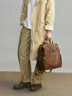 Songmont Large Yore Backpack Sandal - carried by hand with a khaki coat