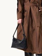 Songmont Small Yore Hobo Bag (Minimal Version) Onyx - carried by hand with a trench coat