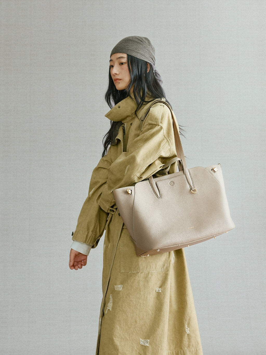 Songmont Large Yore Tote Bag Cobble - carried on the shoulder with an olive trench coat
