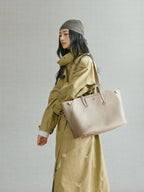 Songmont Large Yore Tote Bag Cobble - carried on the shoulder with an olive trench coat