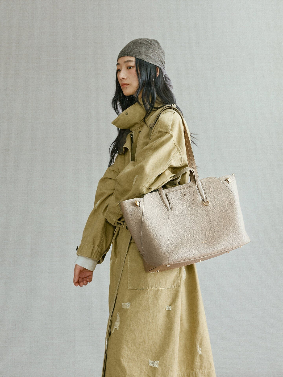 Songmont Large Yore Tote Bag Cobble - carried on the shoulder with an olive trench coat