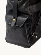 Songmont Small Yore Backpack Onyx - side flap pocket with brass stud, close-up