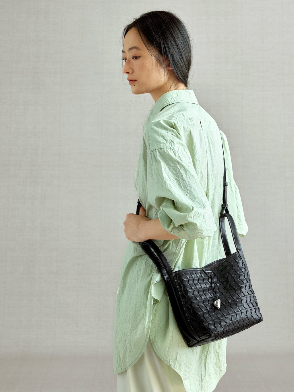 Songmont Lattice Bucket Bag Onyx - worn cross-body, side view