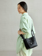 Songmont Lattice Bucket Bag Onyx - worn cross-body, side view