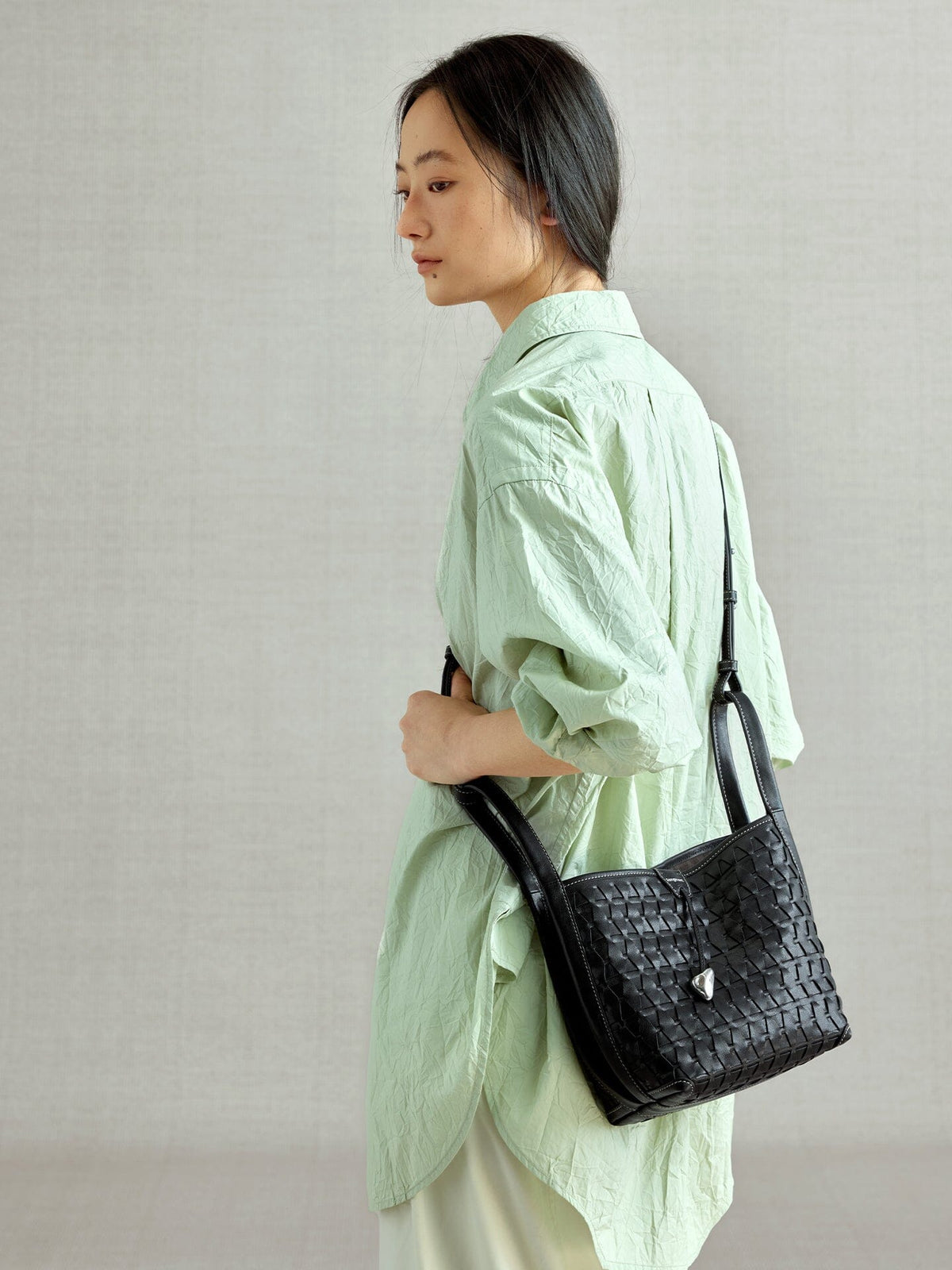 Songmont Lattice Bucket Bag Onyx - worn cross-body, side view