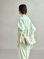 Songmont Lattice Bucket Bag Cloud - worn cross-body, side view