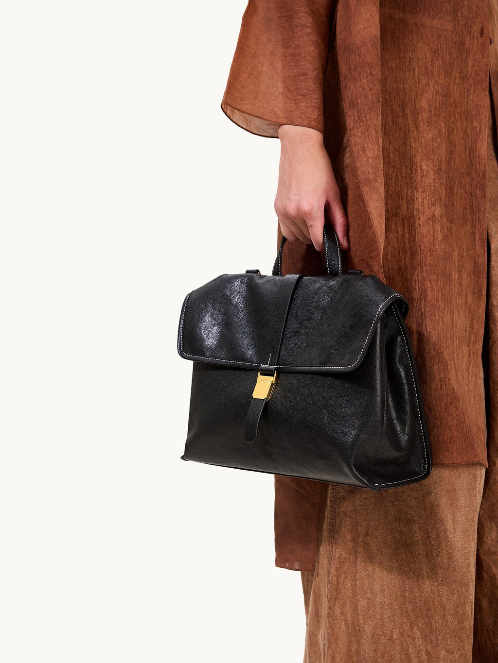 Songmont Small Shan Backpack Onyx - carried by the top handle