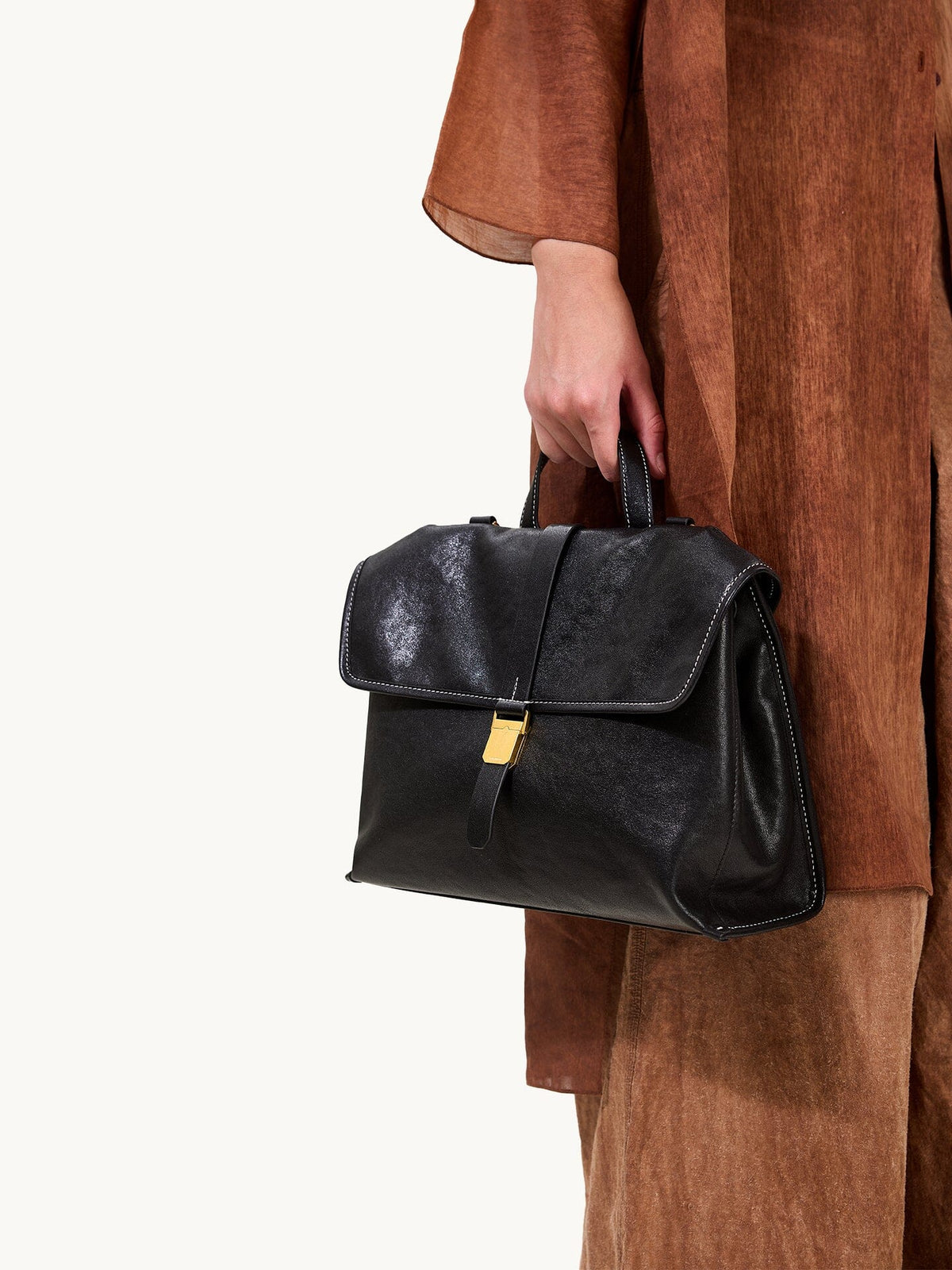 Songmont Small Shan Backpack Onyx - carried by the top handle