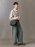 Songmont Small Shan Messenger Bag Onyx - worn at the hip, front view of the flap and pocket