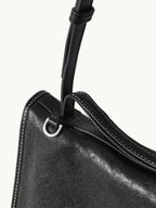 Songmont Small Shan Messenger Bag Onyx - close-up of the strap, silver ring and stitched edge