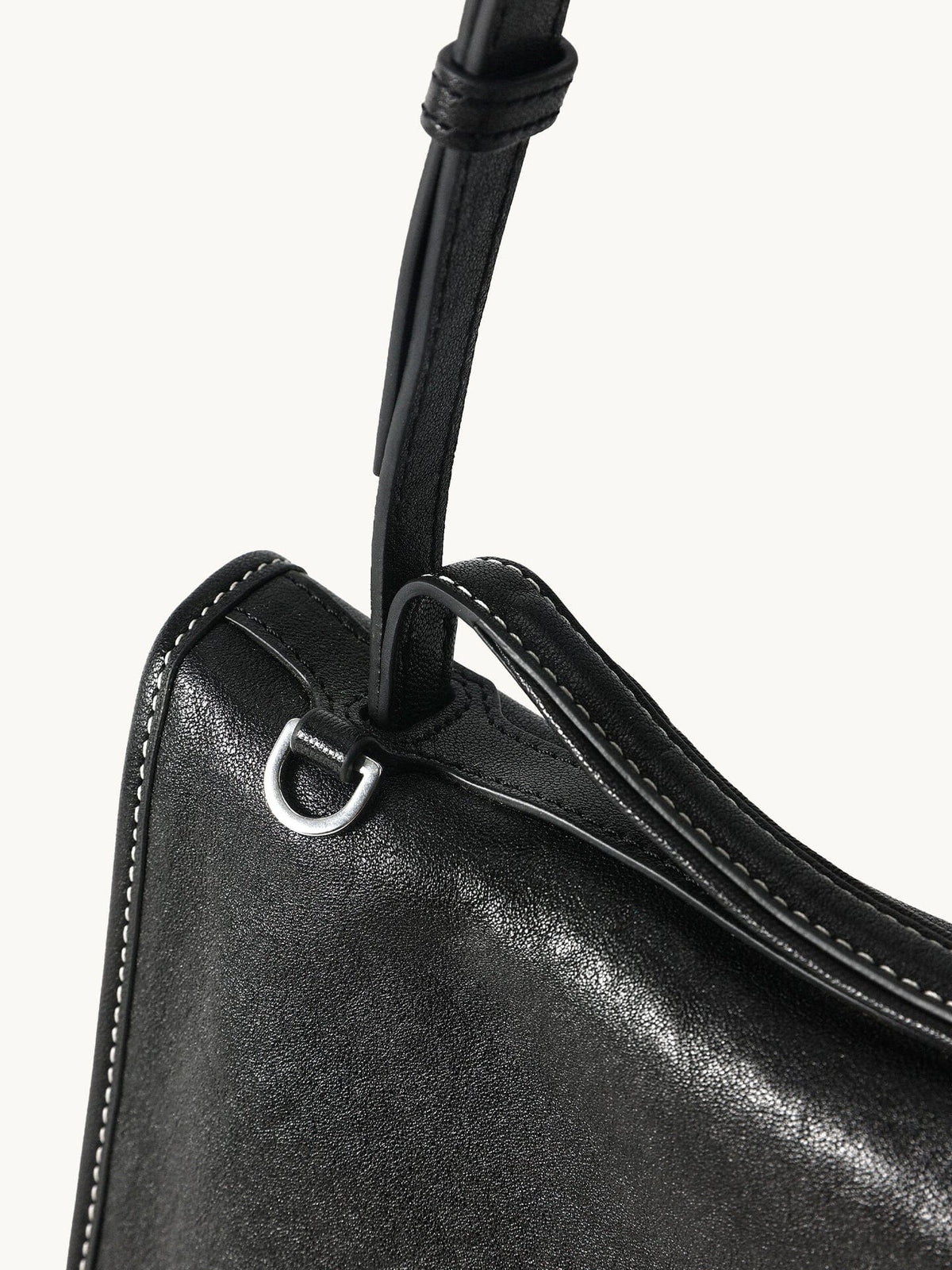 Songmont Small Shan Messenger Bag Onyx - close-up of the strap, silver ring and stitched edge