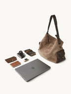Songmont Extra Large Yore Hobo Bag Stone - flat lay with laptop, camera and notebook