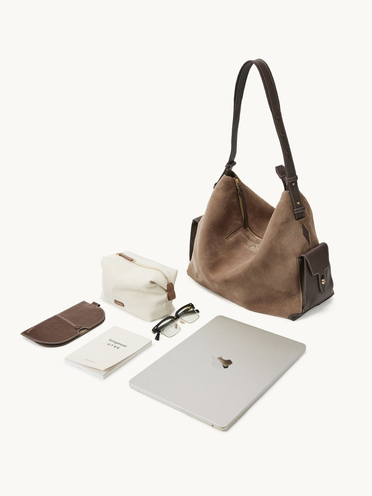 Songmont Large Yore Hobo Bag Stone - laid out with a laptop, glasses and pouch