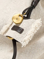 Songmont Medium Gather Backpack Set Canvas - close-up of the charm and frayed tag