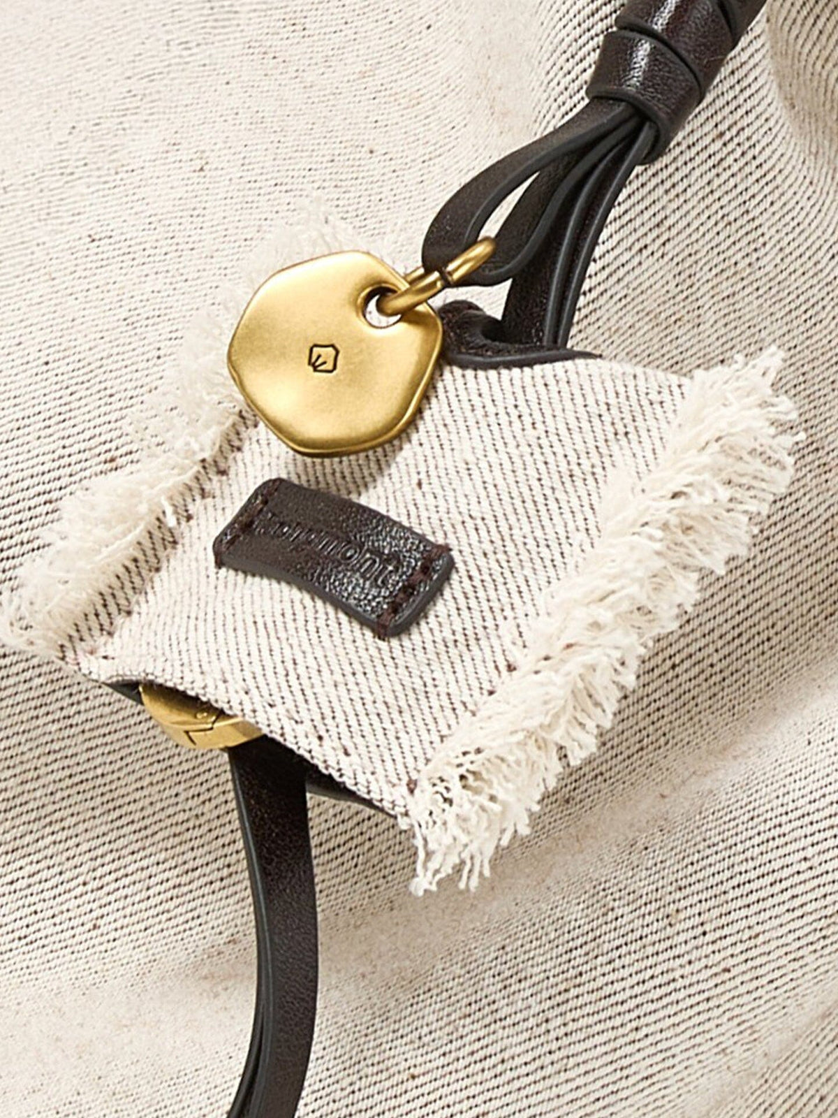 Songmont Medium Gather Backpack Set Canvas - close-up of the charm and frayed tag