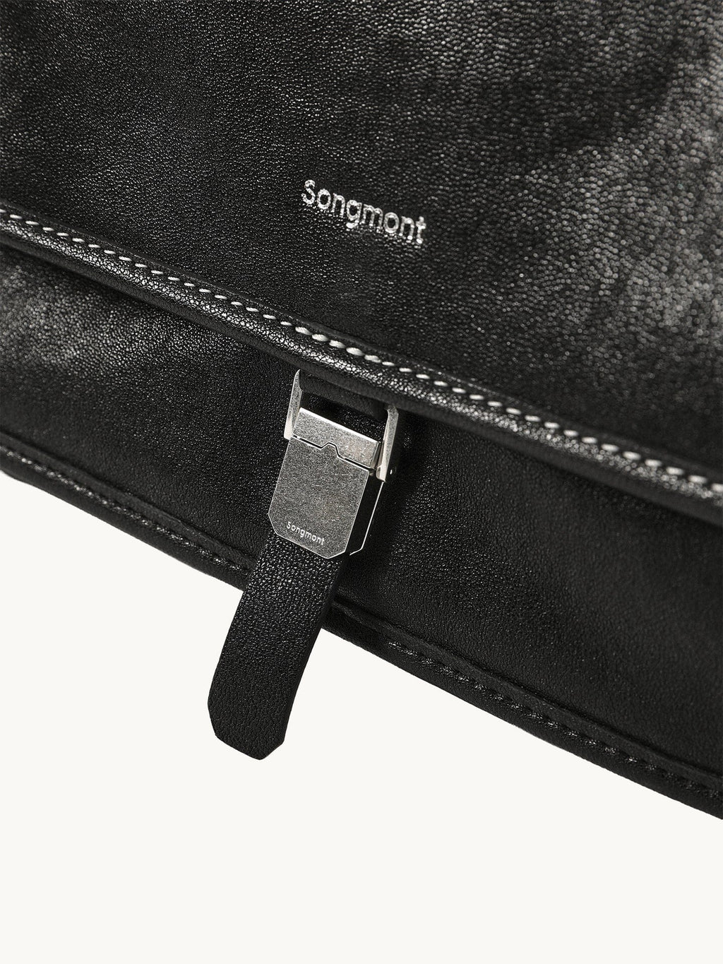 Songmont Medium Shan Messenger Bag Onyx - logo and buckle clasp close-up