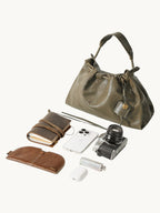 Songmont Small Gather Bag Dark Pine Green - flat lay with everyday items