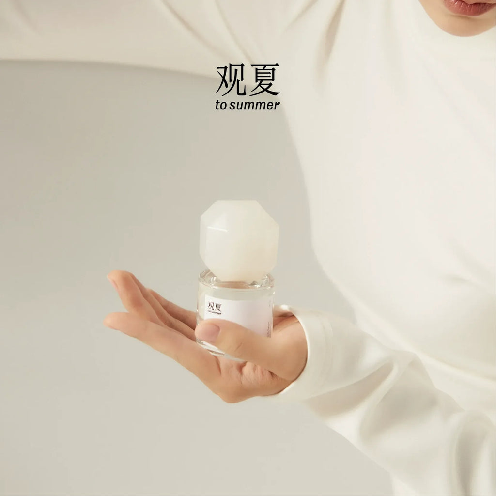 TO SUMMER Nude Eau de Parfum held in an open palm