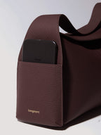 Songmont Drippy Roof Bag Burgundy - phone resting in the strap pocket, close-up
