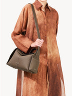Songmont Drippy Roof Bag Taupe - worn crossbody over a rust shirt dress
