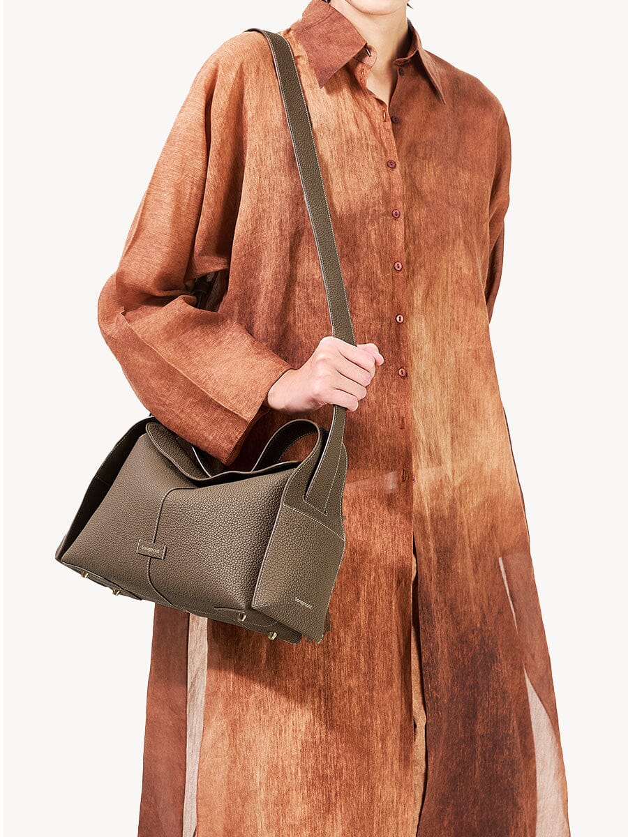 Songmont Drippy Roof Bag Taupe - worn crossbody over a rust shirt dress