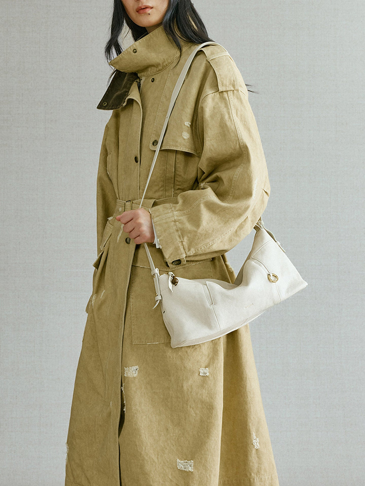 Songmont H Yore Bag Cloud - carried in hand with a khaki trench coat