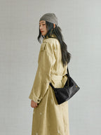 Songmont H Yore Bag Onyx - worn on the shoulder with a khaki trench coat