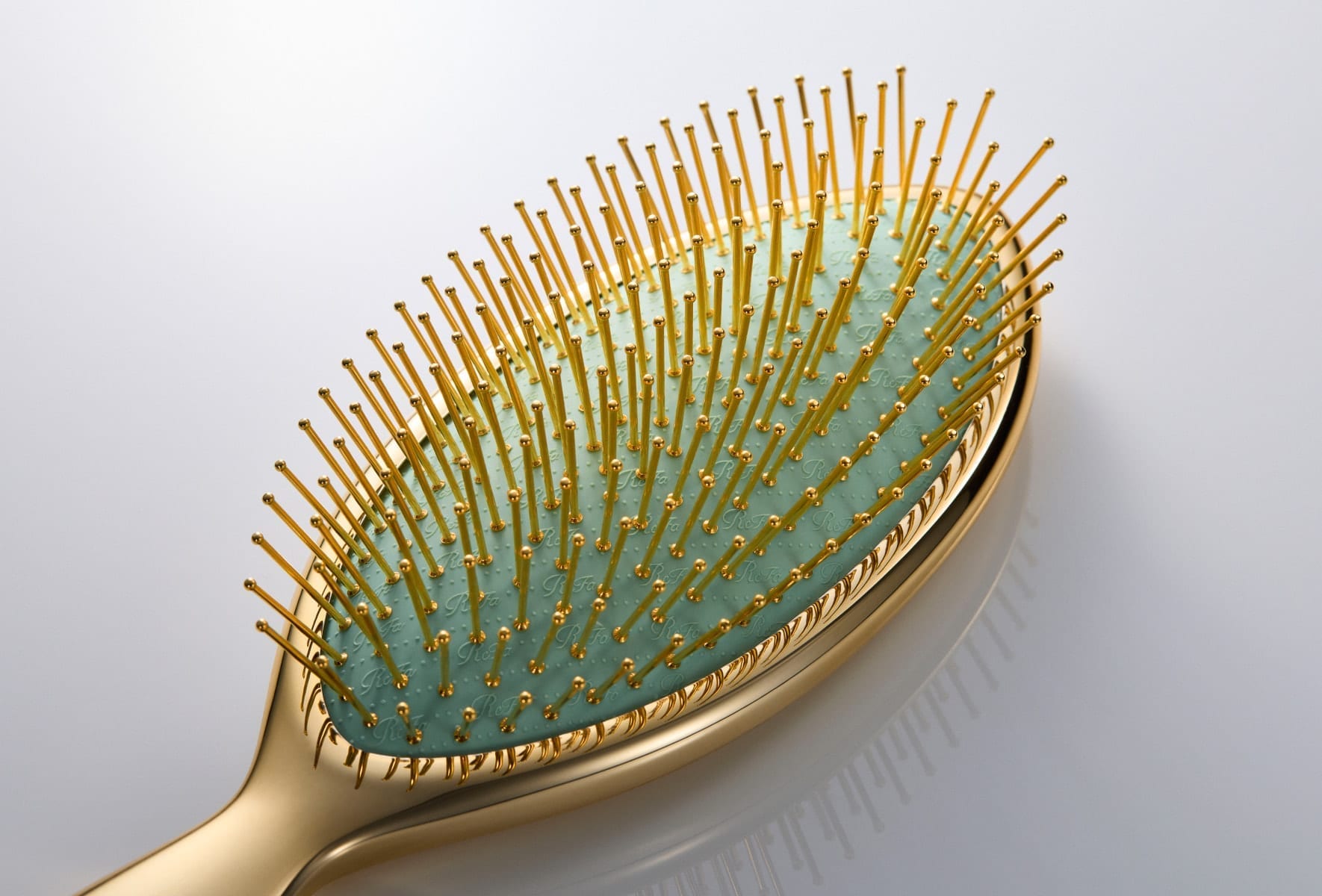 ReFa AURA gold-coated pin close-up