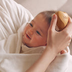 ReFa BABY SLEEPY Heart brushing a smiling baby