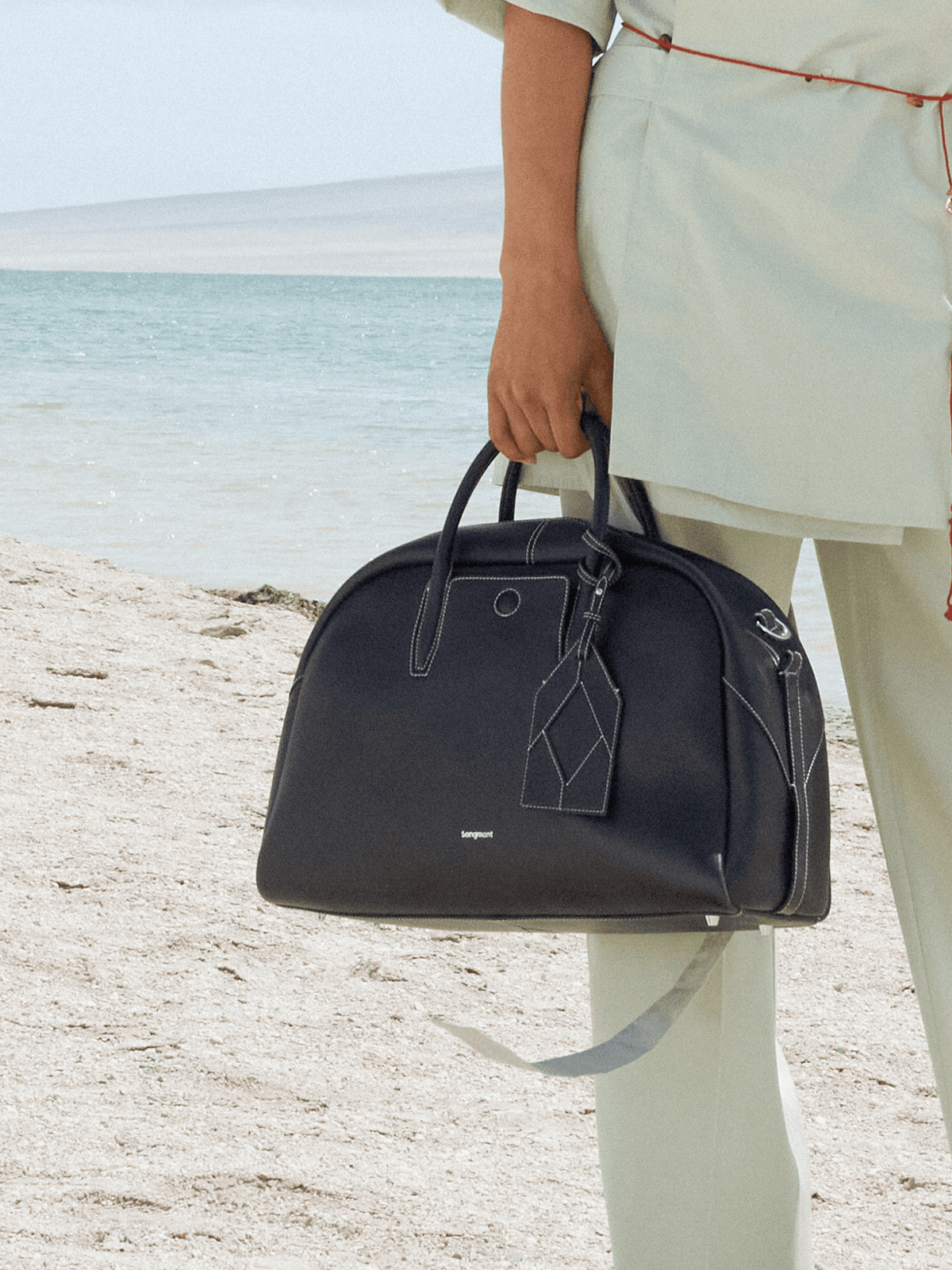 Songmont Large Yore Bowling Bag Ebony - carried by the twin top handles