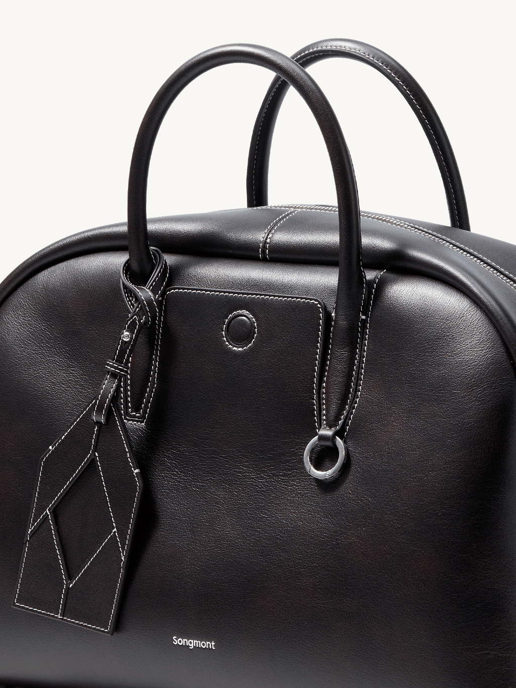 Songmont Large Yore Bowling Bag Ebony - close-up of the top handles and charm tag