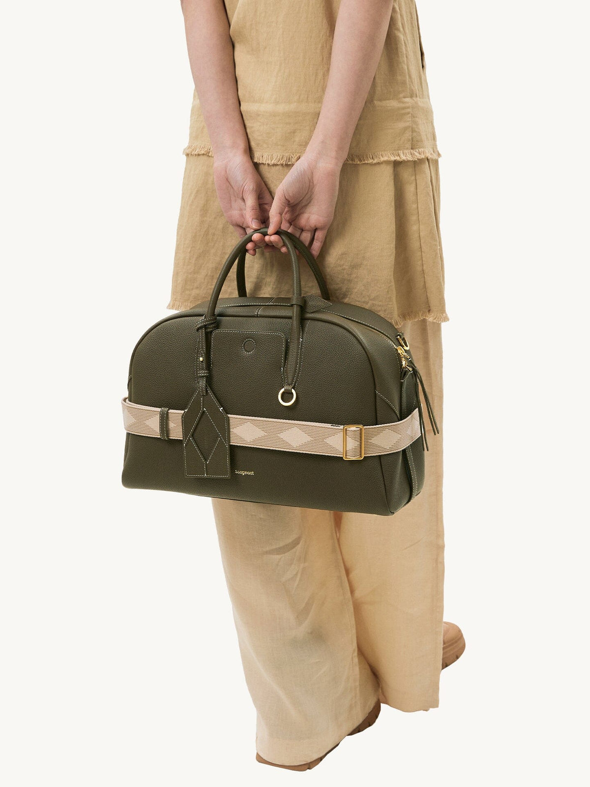 Songmont Large Yore Bowling Bag Moss - held by the handles with the woven strap wrapped round