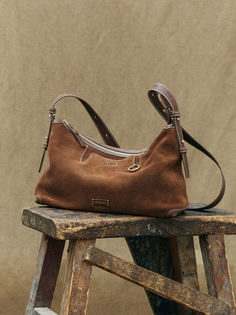 Songmont Large Yore Hobo Bag Sandal Suede - styled on a wooden stool outdoors