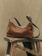 Songmont Large Yore Hobo Bag Sandal Suede - styled on a wooden stool outdoors