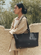Songmont Large Yore Tote Bag Onyx - carried on the shoulder with a linen coat