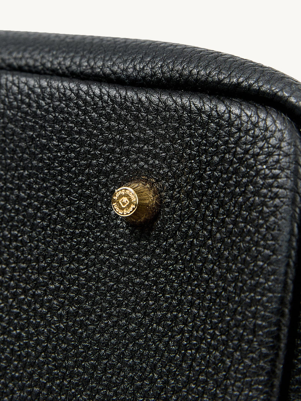 Songmont Large Yore Tote Bag Onyx - close-up of the grain and gold stud at the corner