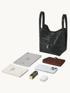 Songmont Lattice Bucket Bag Onyx - flat lay with iPad Mini and essentials