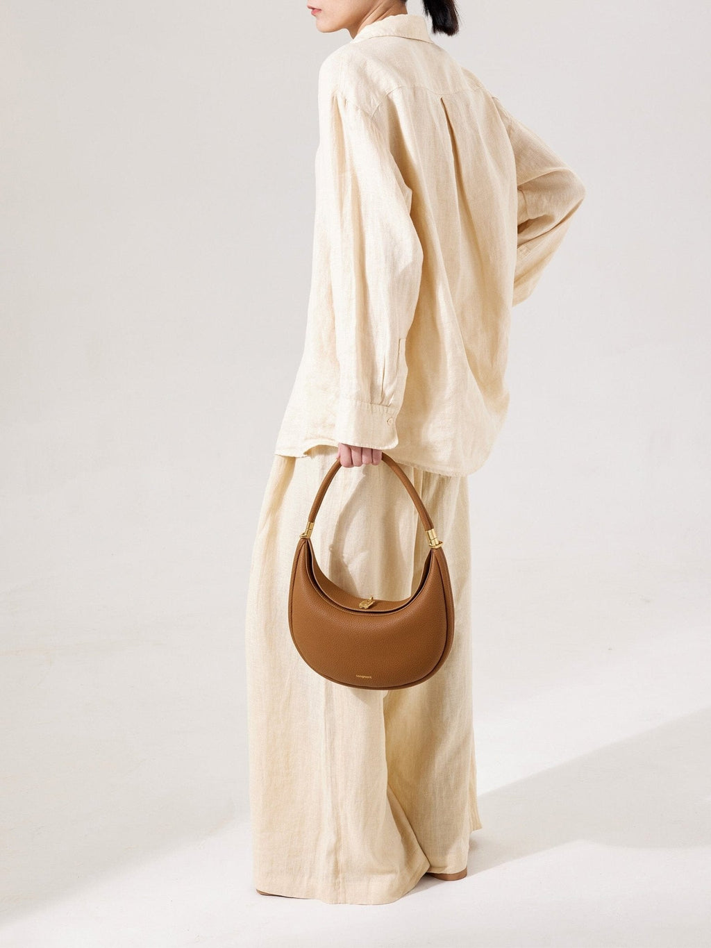 Songmont Luna Bag Mocha - carried by the top handle