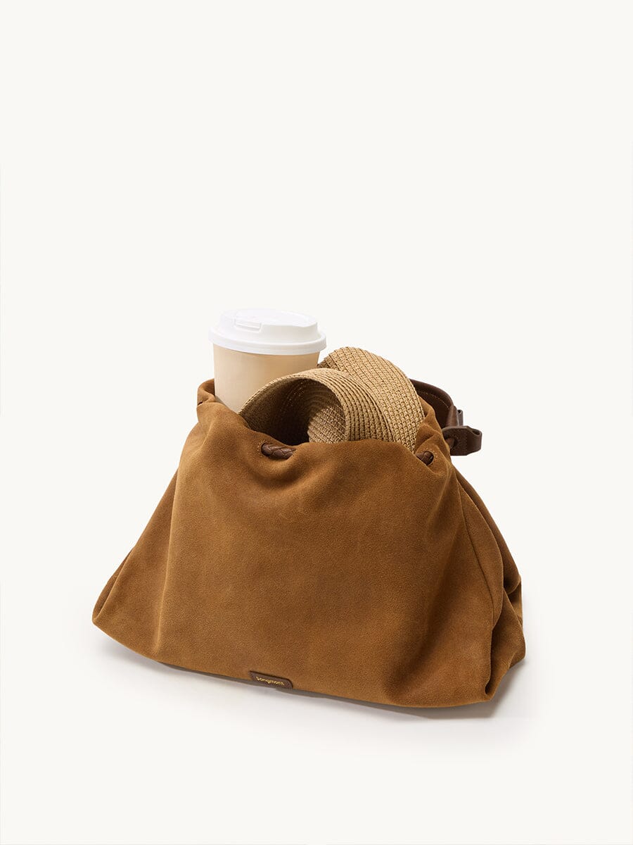 Songmont Medium Gather Bag - Ochre Suede with coffee cup, styled shot