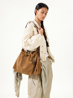 Songmont Medium Gather Bag - Ochre Suede worn with knit sweater
