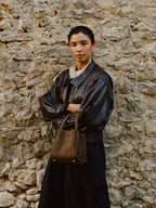 Songmont Medium Song Bag Agarwood worn with a leather jacket