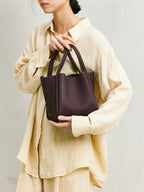 Songmont Medium Song Bag Burgundy held in the arms