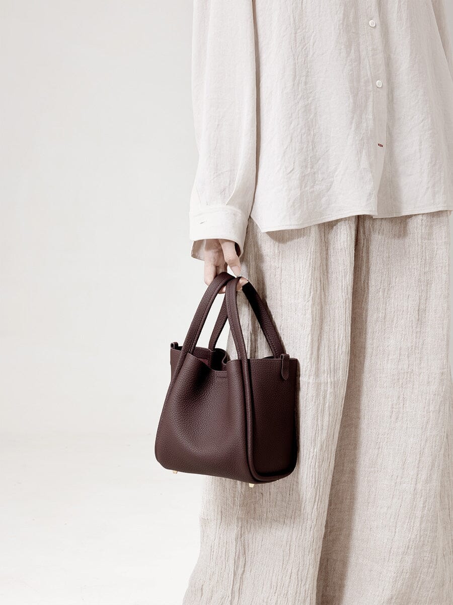 Songmont Medium Song Bag Burgundy carried by the top handles